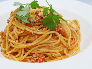 ミートソース スパゲッティ。茹で上げたあとにオリーブオイルで軽く炒めた細い麺と、よく絡むソースのハーモニーをお楽しみください。
